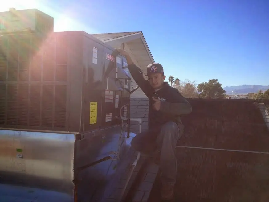 HVAC technician performing Heat Pump Repair on a rooftop unit in Waynesboro